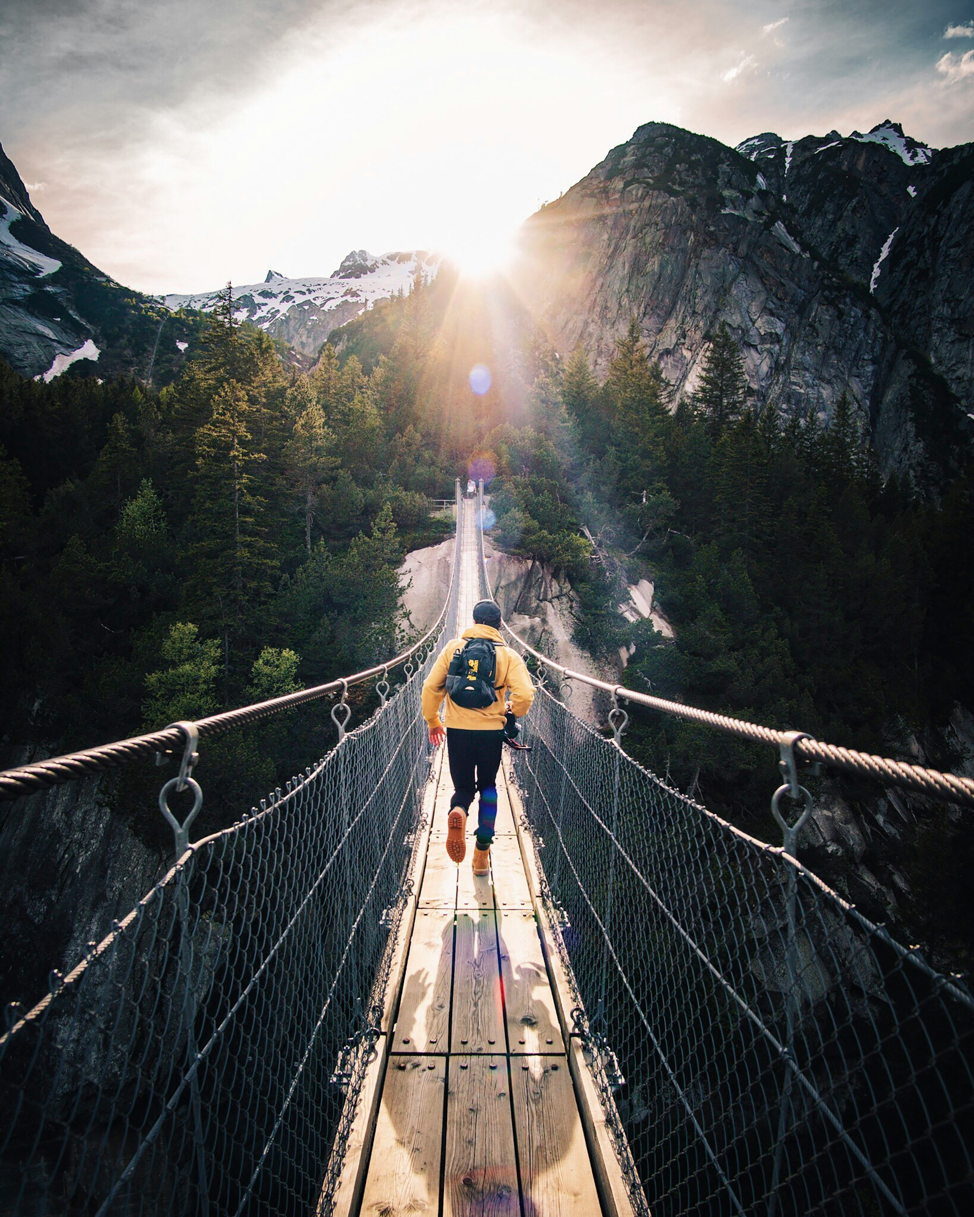 fabio-comparelli-uq2E2V4LhCY-unsplash.webp Person walking across a rope bridge representing balance, focus, and courage in leadership